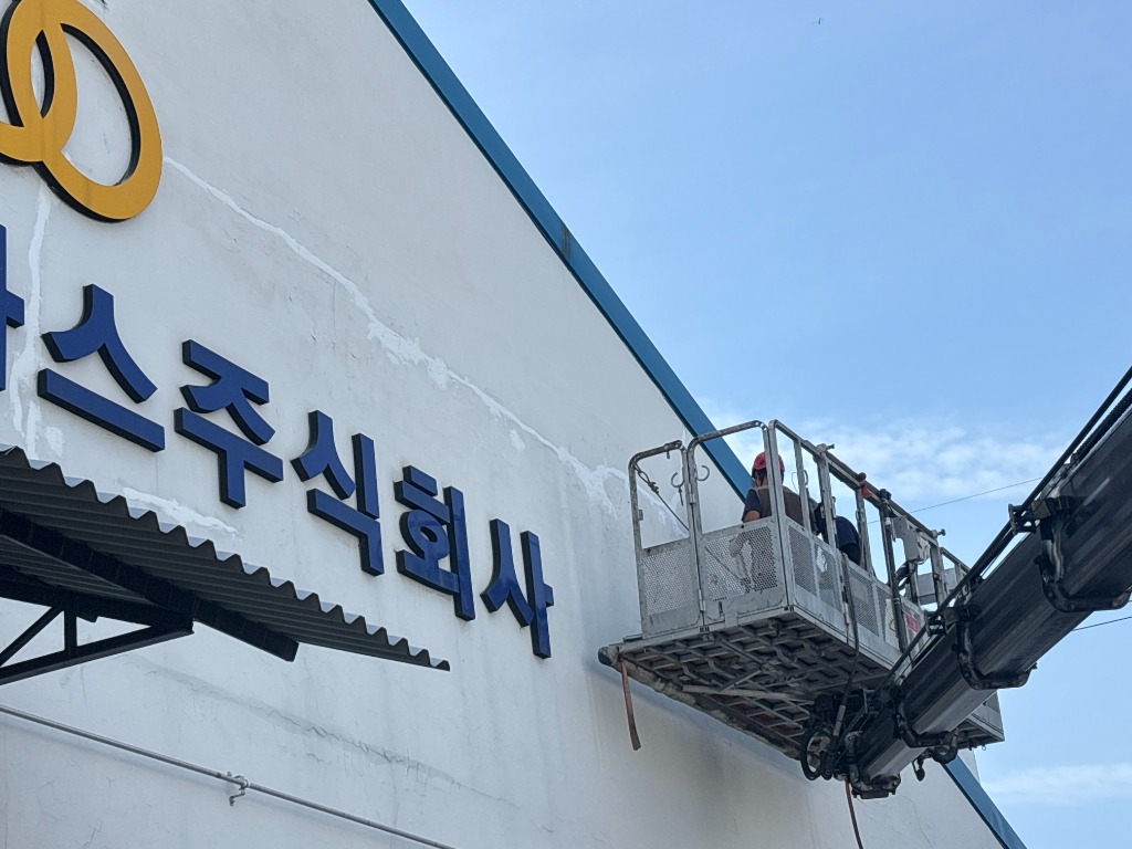 고소작업차를 이용해 공장 외벽의 크랙보수와 방수 작업을 진행하는 현장